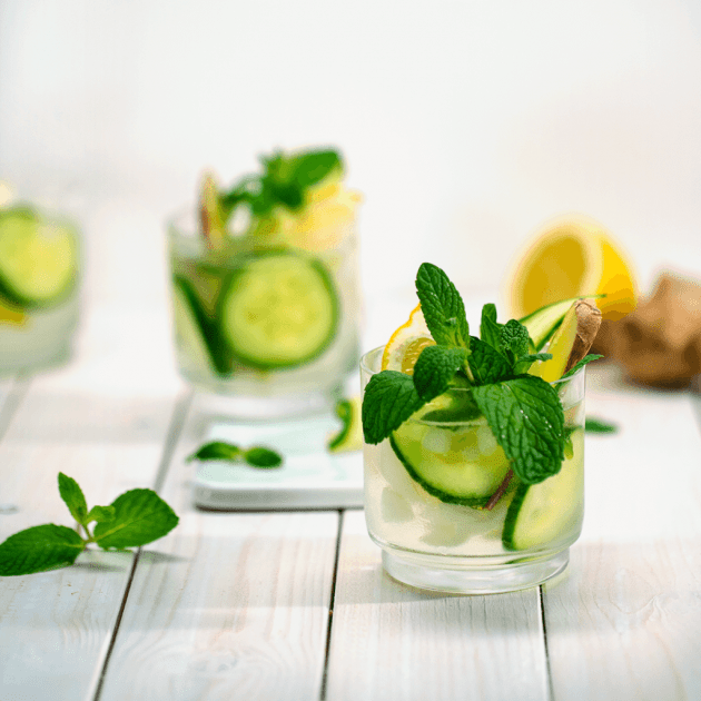 Zwei Gläser Wasser mit Zitrone, Gurke, Ingwer und Minzblätter