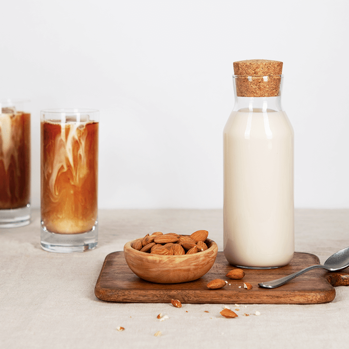 Zwei Gläser Eiskaffee mit einer Flasche Mandelmilch